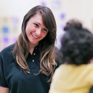 Goddard School childcare franchise teacher smiling at a child